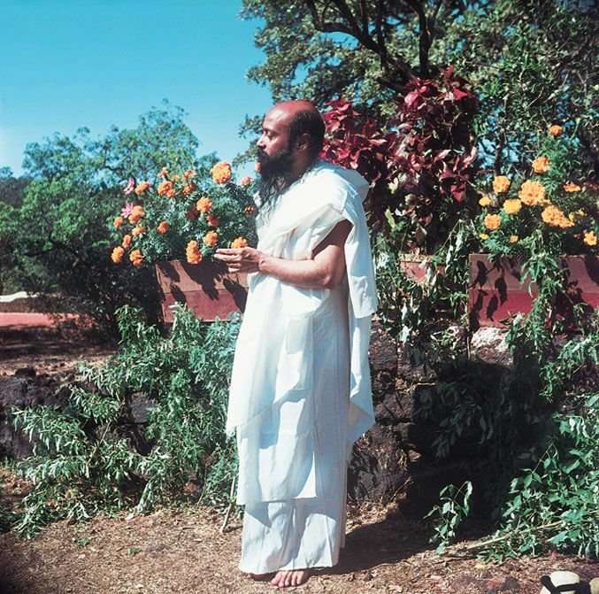 a young, vibrant Osho "earthing" in the garden